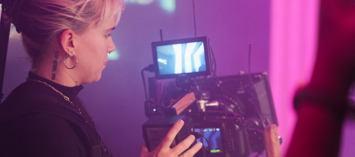 a woman holding a camera in front of a tv